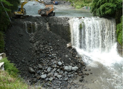 圖 3. (a) 拆壩工程前重型機具預備; (b) 上游砂石開始回填至一號壩下方右岸; (c)、(d) 持續進行泥砂回填工程_圖示