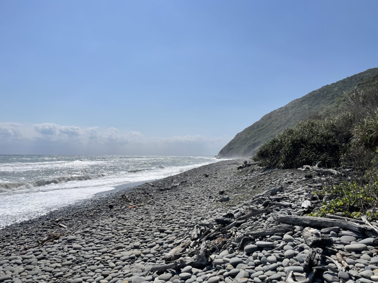 太平洋海浪拍打古道礫石海灘景色圖